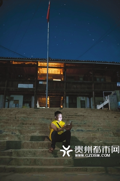 王健强备好课后，在教室外的台阶上等待村民的到来