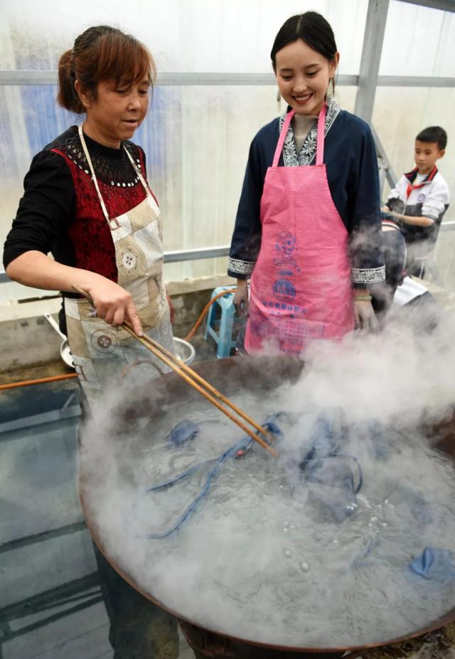 在惠水县的家中，冉光津（中）与母亲将“枫香染”制品放到沸水锅里脱脂