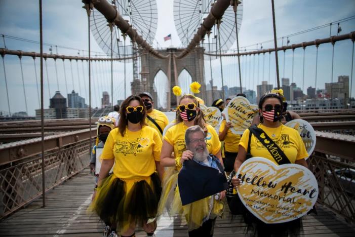 8月7日，游行者手举条幅走过美国纽约布鲁克林大桥，以纪念新冠逝者。新华社/路透